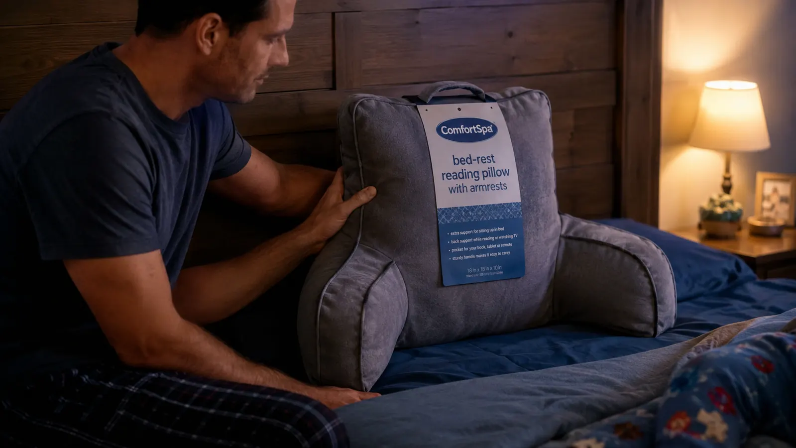Hand propping a grey ComfortSpa reading pillow against a wooden headboard before bedtime