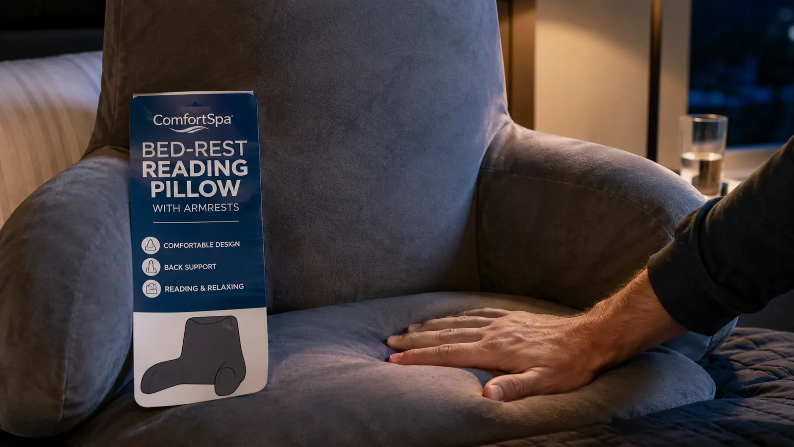 Hand pressing down on the firm foam base of a grey ComfortSpa reading pillow to show how stiff it feels straight out of the box